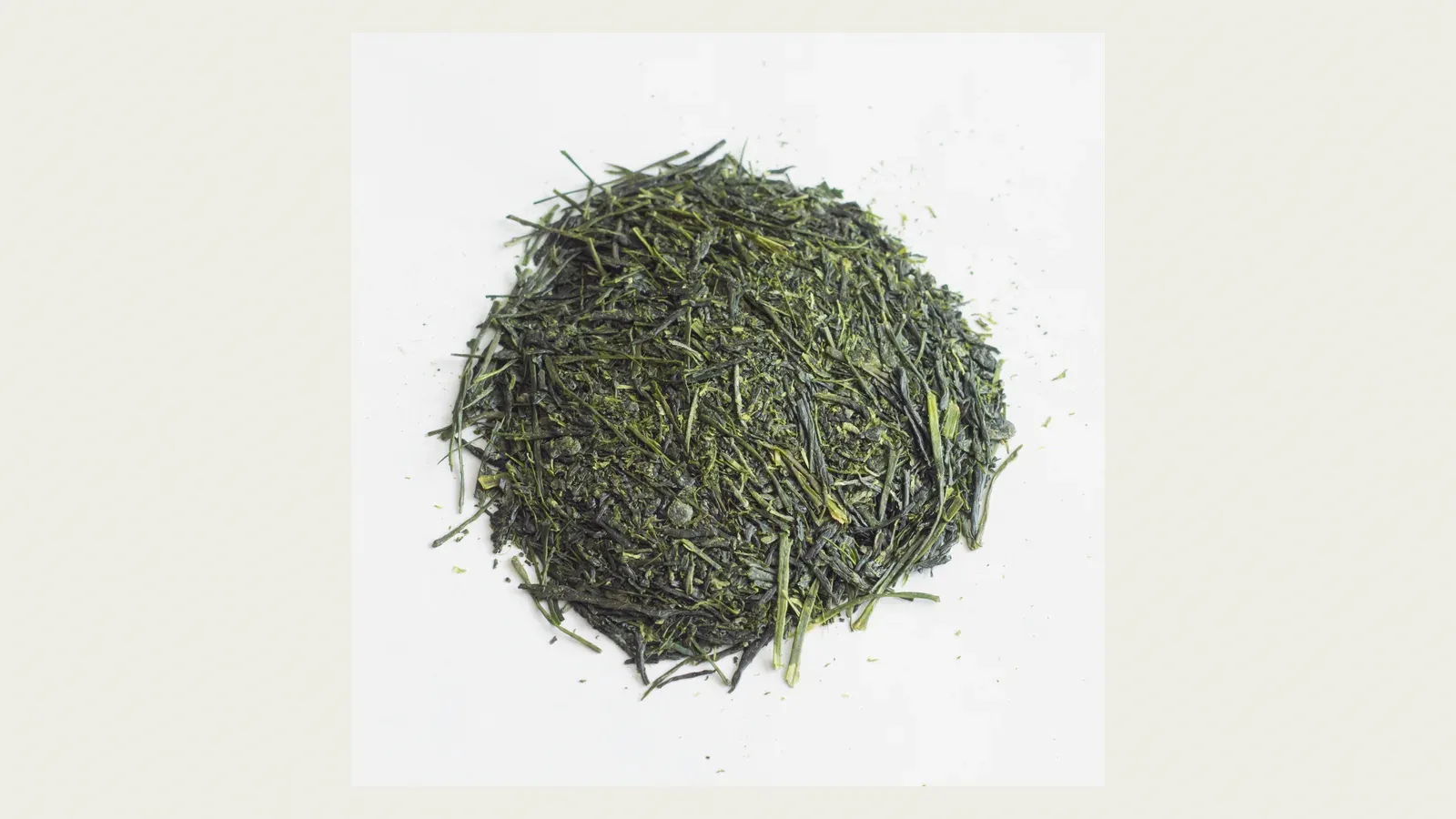 A dense mound of dark green sencha needles, each leaf rolled to a fine point