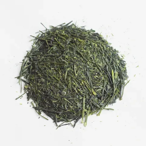 A dense mound of dark green sencha needles, each leaf rolled to a fine point