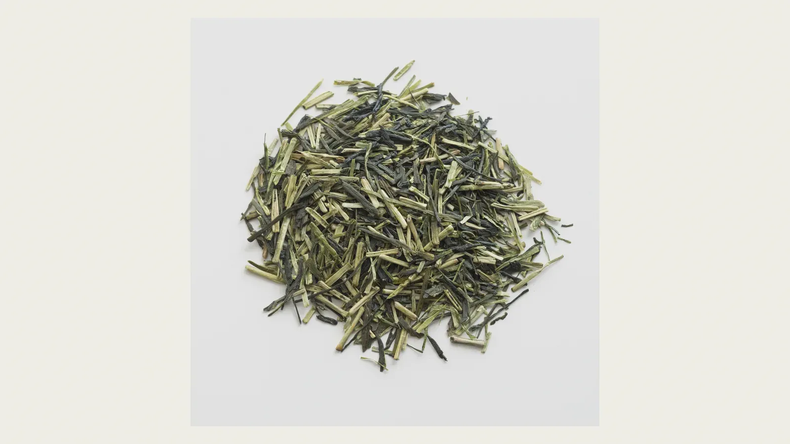 A pile of kukicha — pale cream stems tangled with slender green leaf