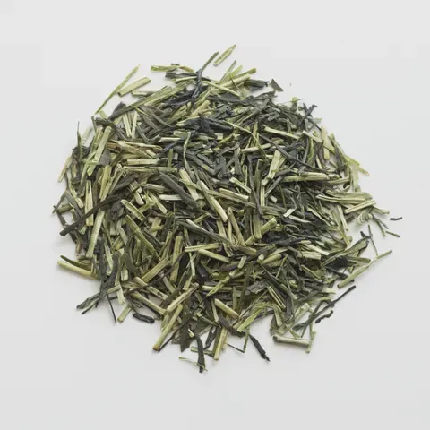 A pile of kukicha — pale cream stems tangled with slender green leaf